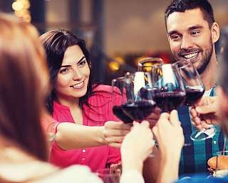 Gruppo di amici che brindano con bicchieri di vino rosso.