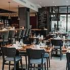 Elegantes Restaurant mit gedeckten Tischen und einer Bar.