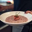 Ein Teller Risotto mit einer Wurstscheibe und Thymian.