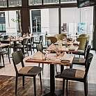 Innenansicht eines Restaurants mit gedeckten Tischen und Stühlen.