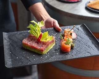 Un piatto elegante con tartare di pesce e salmone affumicato.